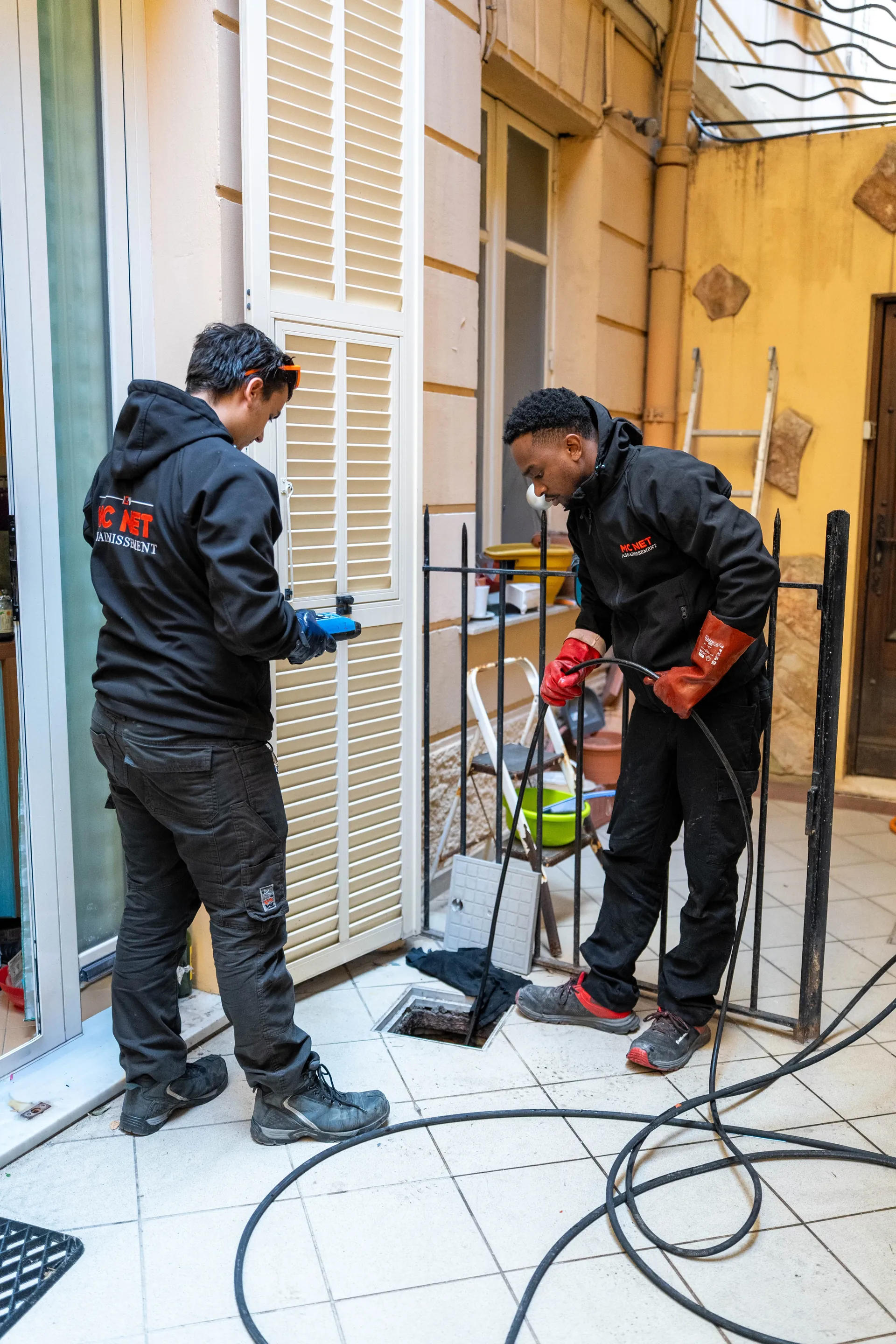 MC NET Sanitation technicians performing high-pressure drain unblocking