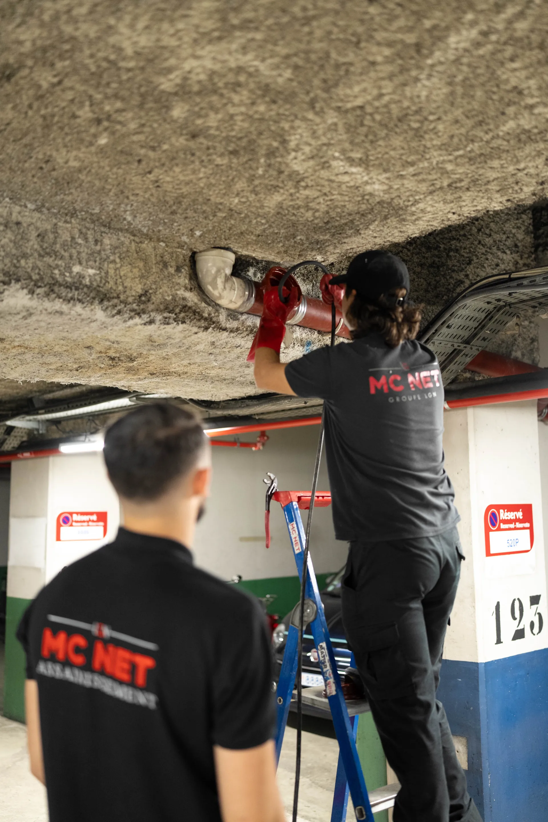 MC NET Sanitation technicians working on underground car park pipework