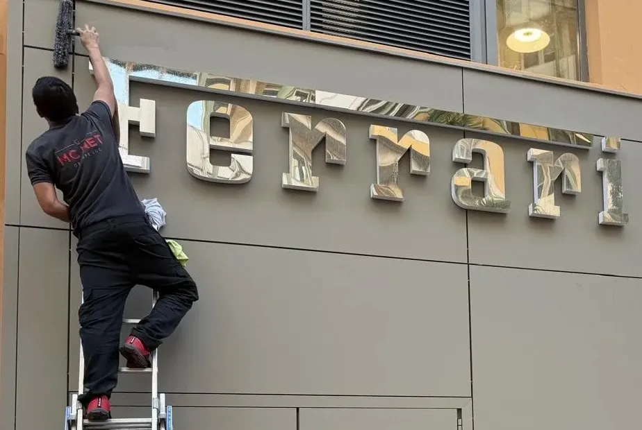 MC NET Cleaning operative cleaning a luxury storefront facade in Monaco